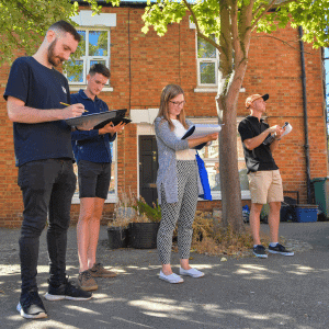 Image of a group of surveyors observing a property and taken notes on their clipboards