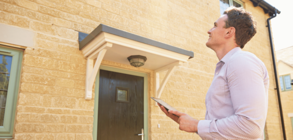 Image shows a valuer assessing a house.