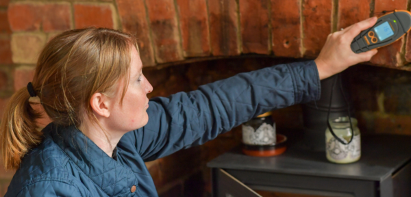 Image shows a residential surveyor testing for damp.