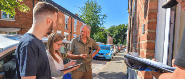 Surveyors Training outside a property, taking notes diligently